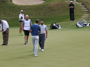 Oosthuizen and Dustin Johnson shake hands after their match